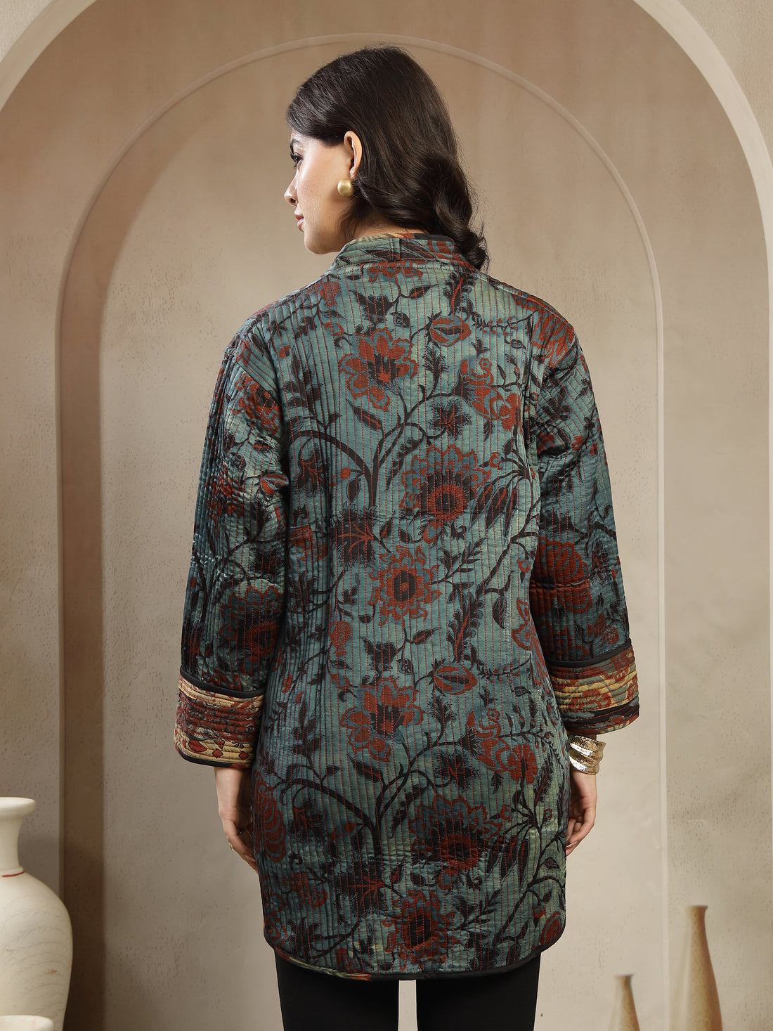 Woman wearing a patterned jacket against a beige background